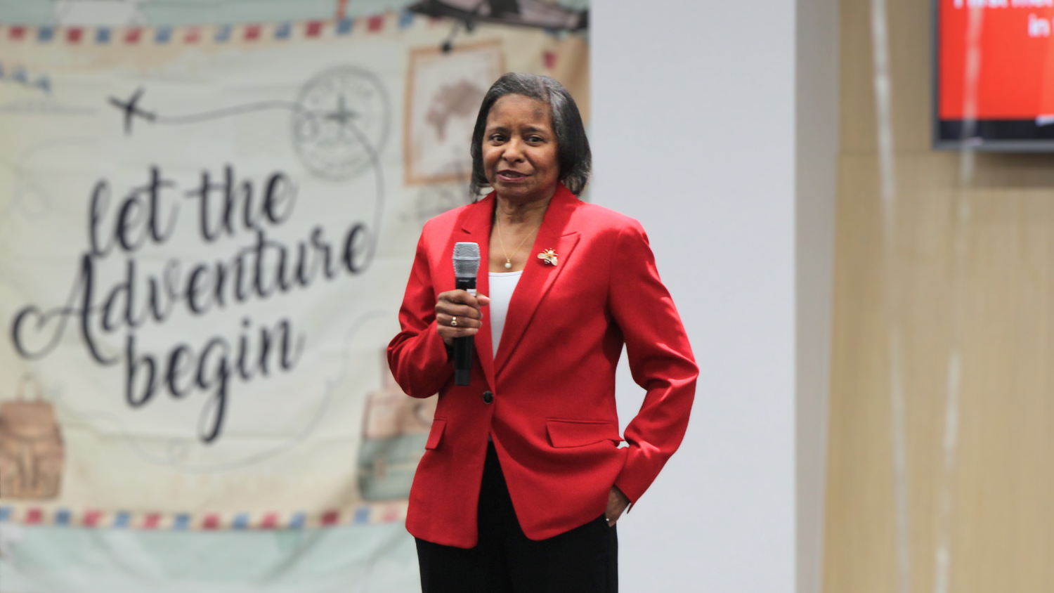 Mardecia holds a microphone and gives a speech